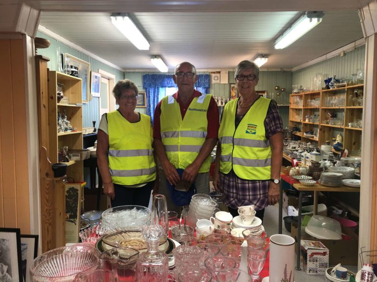 MANGE ILDSJELER: Aud Huse (fra venstre), Rolv Olsen og Marit Engemoen er blant ildsjelene som sørger for å holde Klokkergardens loppemarked i gang på torsdager. Foto: Malin Therese Strand.