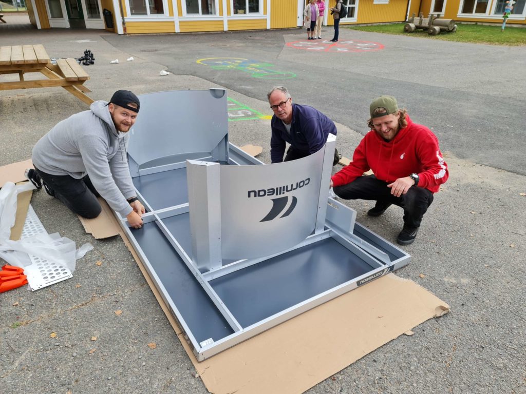 KAN STÅ UTE: Et nytt rullende og flyttbart bordtennisbord var også en av gavene som ble overrekt fra Ådalsbruk Velforening. Monteringen ble overlatt til barneveileder Olav Ophus (fra venstre), vaktmester Jan Gulbrandsen og barneveileder Karl Anders Pettersen på Ådalsbruk skole. Bordtennisbordet kan stå utendørs.