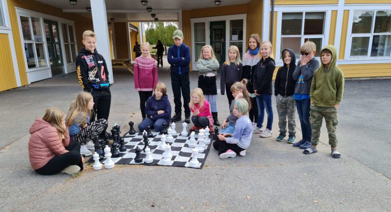KLART TIL BRUK: Vennelek- og elevrådsrepresentanter fra 3. til 6. klasse på Ådalsbruk skole fikk overlevert sjakkbrett med store brikker som ble tatt i bruk umiddelbart.