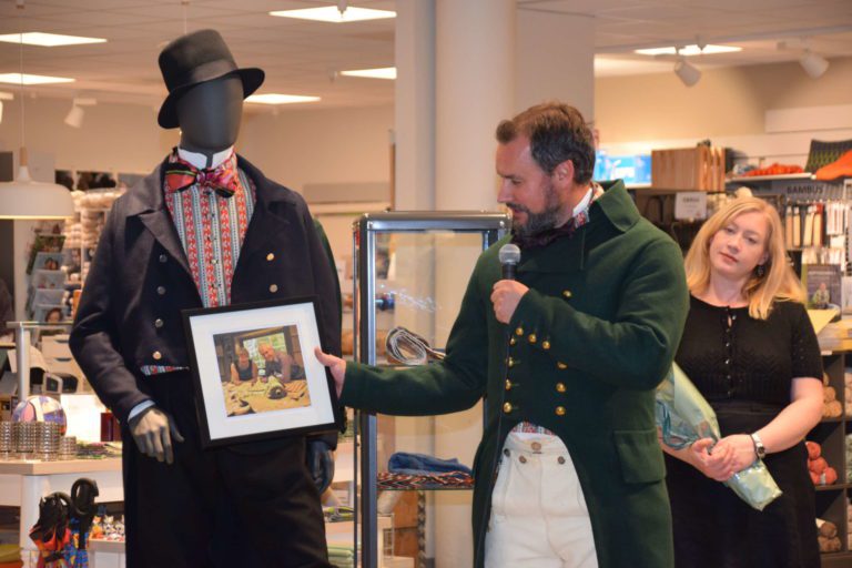 BLE RELANSERT: Allerede står rundt 50 personer i kø for å få sin mannsbunad fra Hedemarken. Her ser vi Ole Kristen Tømmerholen, som er sønn av Odd Arnfinn Tømmerholen, og syerske Heidi Eriksen ved Husfliden Hamar.