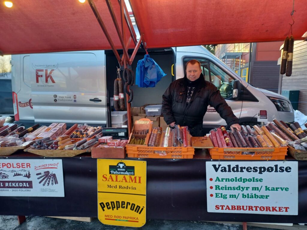 SELGER MYE ELGPØLSE: Kent Nergården kom med sin spekebod til Løtenhallen.  Her var noe for enhver smak, og det gikk mye spekepølser med smak av rødvin. FOTO: Line Larsen