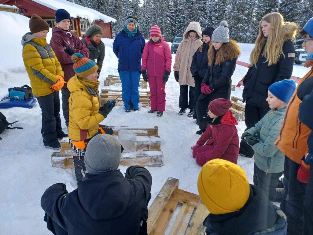 VELDIG SPENNENDE: Ida lærer elvene hvordan man skal skjære i isen, og hadde en veldig lydhør klasse foran seg. FOTO: Line Larsen
