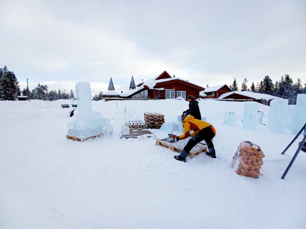 FORARBEID: De store isblokkene var fraktet til Budor på forhånd, og kunstnerne brukte motorsaga før elvene kom, så det ble nok is til alle. FOTO: Line Larsen