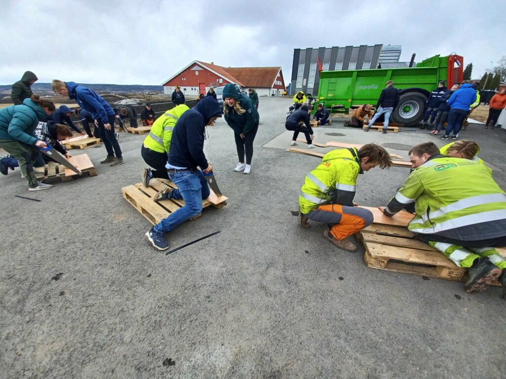 HANDYMAN: Hvert lag fikk hver sin palle. På den måtte de spikre fast ett visst antall plater, uten å  sitte igjen med noe restmateriale. Alt skulle være etter mønster, og gikk på tid. FOTO: Line Larsen