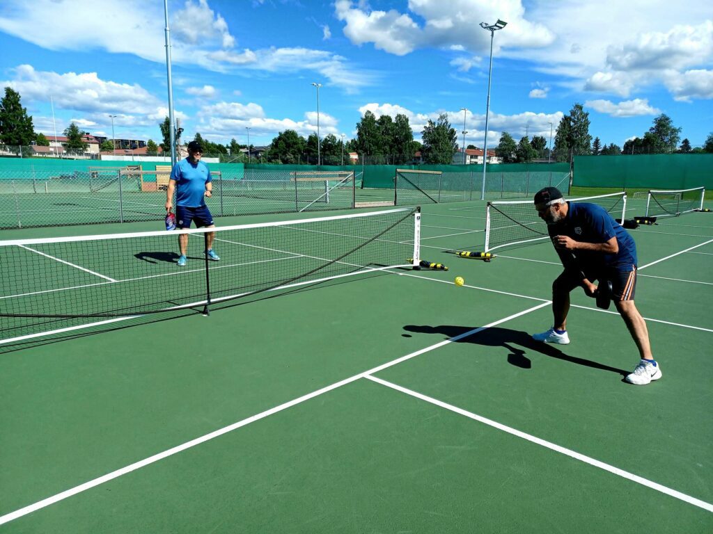 MINDRE BANE: I Pickleball spilles det på mindre bane enn i Tennis. Mange prinsipper er like fra tennis og badminton, og lett å lære. Stig og Rune tar en runde, for å vise hvordan det spilles. FOTO: Line Larsen